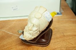 A MEERSCHAUM SMOKING PIPE, SHAPED AS A GENTLEMAN'S HEAD WITH TURBAN WITH AMBER MOUTHPIECE ON LEATHER