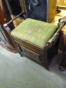 AN EDWARDIAN MAHOGANY PIANO STOOL WITH END RAISED HANDLES, OVER CUPBOARD BASE