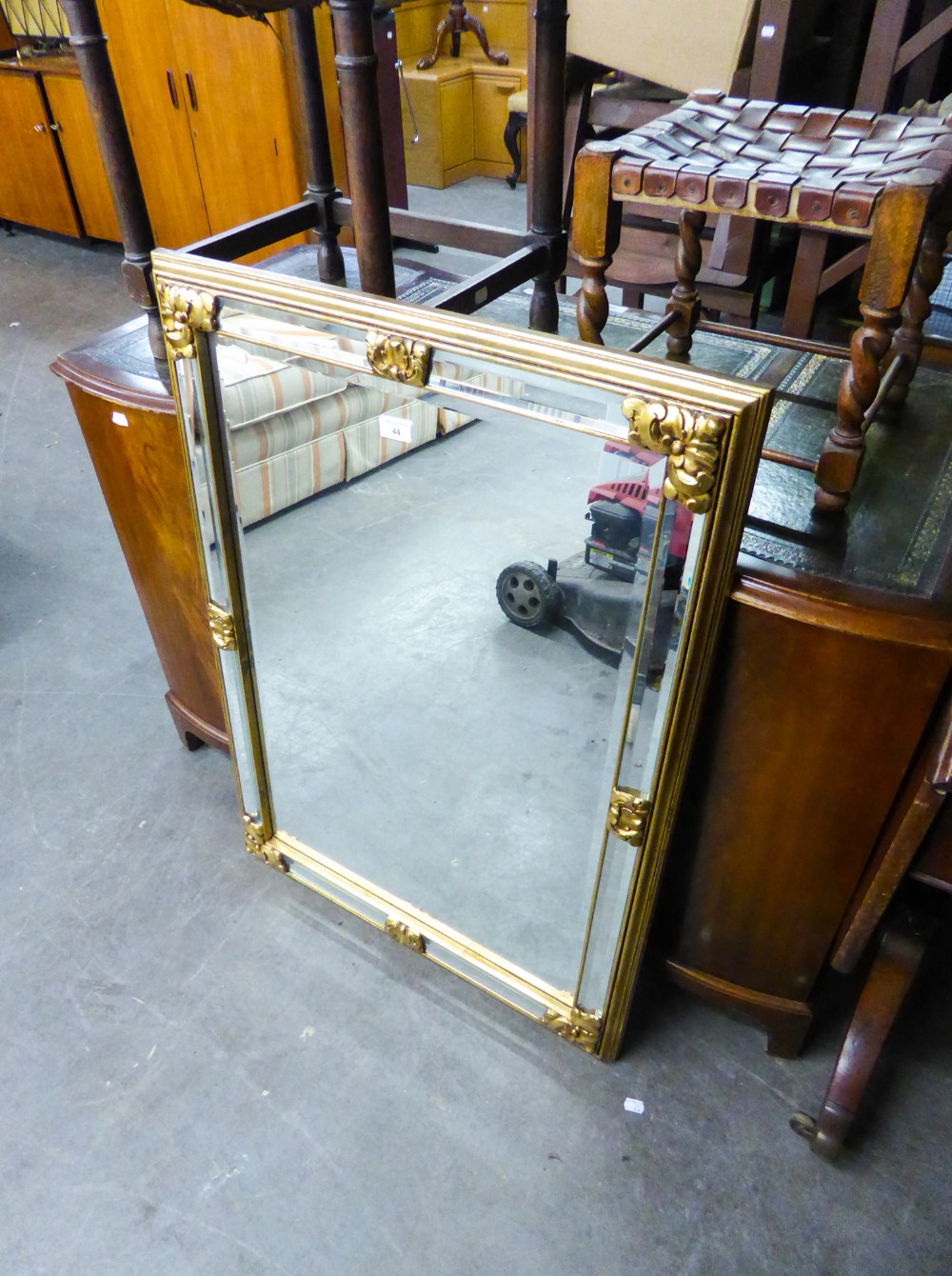 A RECTANGULAR BEVELLED EDGE WALL MIRROR IN GILT FRAME