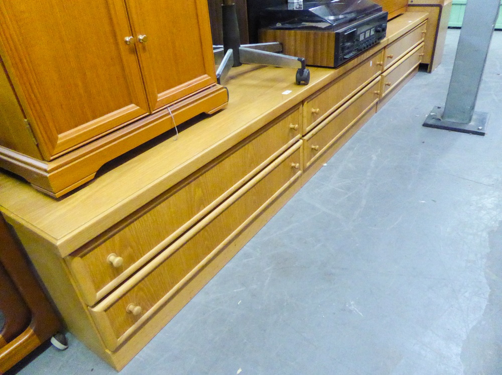 A LARGE LOW LIGHTWOOD LOUNGE UNIT OF FOUR LONG DRAWERS AND A MATCHING TWO DRAWER UNIT