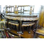 AN EARLY 20TH CENTURY LACQUERED ORIENTAL HARDWOOD HIGH RELIEF CARVED NEST OF SEVEN TABLES, EACH WITH