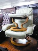 A LEATHER CREAM COLOURED RECLINING ARMCHAIR AND A MATCHING FOOT STOOL (2)