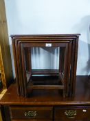 A NEST OF FOUR INDIAN TEAK WOOD OBLONG COFFEE TABLES WITH CARVED BORDERS, ON SQUARE TAPERING LEGS