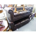 A ROUND BACKED CHESTERFIELD THREE SEATER SETTEE, BUTTON UPHOLSTERED IN DARK BROWN HIDE