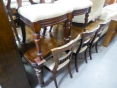 A VICTORIAN MAHOGANY EXTENDING DINING TABLE, WITH TWO LEAVES, ON TURNED FLUTED SUPPORTS AND CASTORS