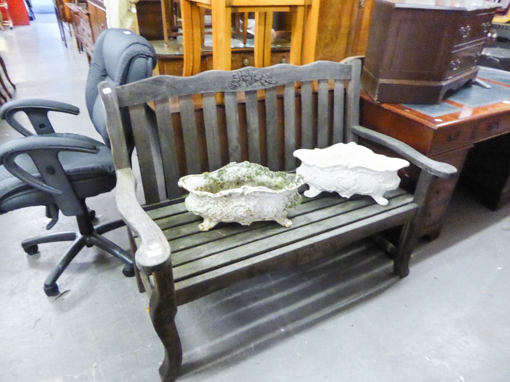 A TEAK GARDEN BENCH WITH TOP TOP AND FLORAL DECORATION