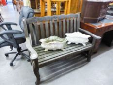 A TEAK GARDEN BENCH WITH TOP TOP AND FLORAL DECORATION