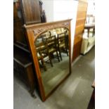 AN EARLY/MID 20th CENTURY MAHOGANY FRAMED WALL MIRROR, CARVED TOP RAIL OVER SHAPED MIRROR