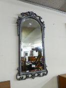AN ARCHED TOPPED BEVELLED EDGE WALL MIRROR, IN SILVERED FINISH FRAME