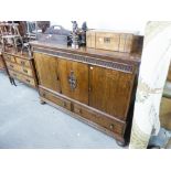A 1930's OAK SIDEBOARD WITH THREE DOORS ABOVE THREE DRAWERS, WITH FITTED INTERIOR DRAWERS AND LOW