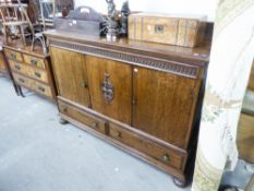 A 1930's OAK SIDEBOARD WITH THREE DOORS ABOVE THREE DRAWERS, WITH FITTED INTERIOR DRAWERS AND LOW