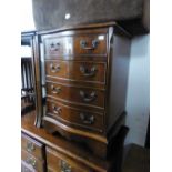 A SMALL FOUR DRAWER SERPENTINE FRONTED CHEST WITH DROP HANDLES
