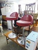 A PAIR OF ADJUSTABLE MODERN BAR STOOLS HAVING BERRY HID PAD SEAT AND SHORT BACK ON CHROME STANDS (2)