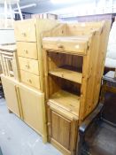 A PINE TALL NARROW UNIT WITH OPEN SHELVES AND CUPBOARD BASE, AND A TALL NARROW CHEST OF FOUR DRAWERS