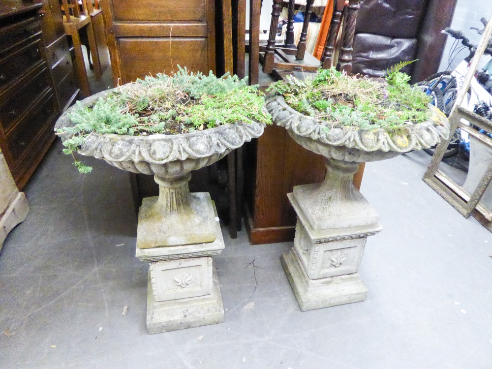 A PAIR OF COMPOSITION GARDEN URNS WITH OUT-TURNED RIMS TO SHALLOW BOWLS, ON SQUARE PEDESTALS (2)