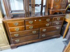 A REPRODUCTION MAHOGANY LARGE CHEST OF DRAWERS/SIDEBOARD, HAVING FOUR SHORT EITHER SIDE OF TWO