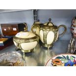 A THREE PIECE TEA SERVICE OF OSTRICH EGGS WITH BRASS MOUNTS (SOME DAMAGE)