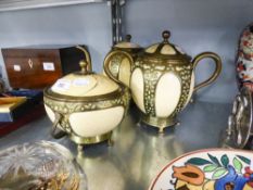 A THREE PIECE TEA SERVICE OF OSTRICH EGGS WITH BRASS MOUNTS (SOME DAMAGE)