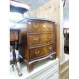 A SMALL FIGURED WALNUTWOOD SERPENTINE CHEST OF THREE LONG DRAWERS ON BRACKET FEET, 1'9" WIDE AND A