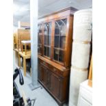 A REPRODUCTION BOOKCASE, GLAZED UPPER PORTION WITH DRAWERS AND CUPBOARDS UNDER