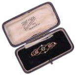 A delicate Edwardian 15ct gold peridot and pink sapphire set scroll brooch,