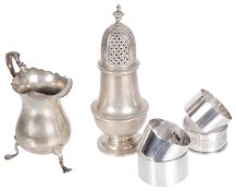 A contemporary silver cream jug, silver sifter and four silver napkin rings