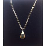 A contemporary amber tear drop pendant on fancy 9ct gold chain