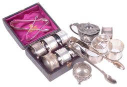 A collection of Victorian and Edwardian silver including napkin rings, sugar nips and cruet