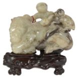 A late 19th century Chinese carved jade figure of a recumbent horse with two monkeys climbing upon h