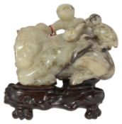 A late 19th century Chinese carved jade figure of a recumbent horse with two monkeys climbing upon h