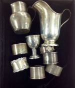 A collection of Edwardian and later silver cream jugs, napkin rings and egg cup