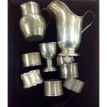 A collection of Edwardian and later silver cream jugs, napkin rings and egg cup