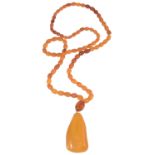 A graduated butterscotch amber necklace and pendant