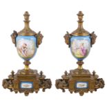 A pair of Sevres style porcelain and gilt metal urns