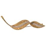 An elegant 18ct gold diamond set stylized leaf cocktail brooch