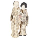 A late 19th century Japanese Meji period ivory Okimono of a lady and a gentleman