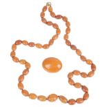 A butterscotch amber necklace and brooch; a amber brooch (2)