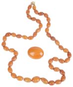 A butterscotch amber necklace and brooch; a amber brooch (2)