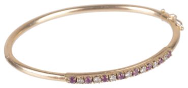 A delicate Continental ruby and diamond set hinged bangle