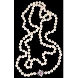 An opera length string of cultured pearls with ruby and diamond clasp
