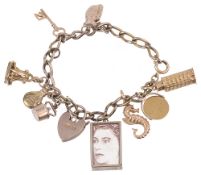 A collection of gold bracelet charms suspended from a gilt bracelet