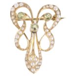 An attractive Art Nouveau peridot and seed pearl scroll brooch