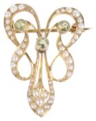 An attractive Art Nouveau peridot and seed pearl scroll brooch