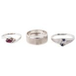 A white gold wedding band and two white gold gem set rings