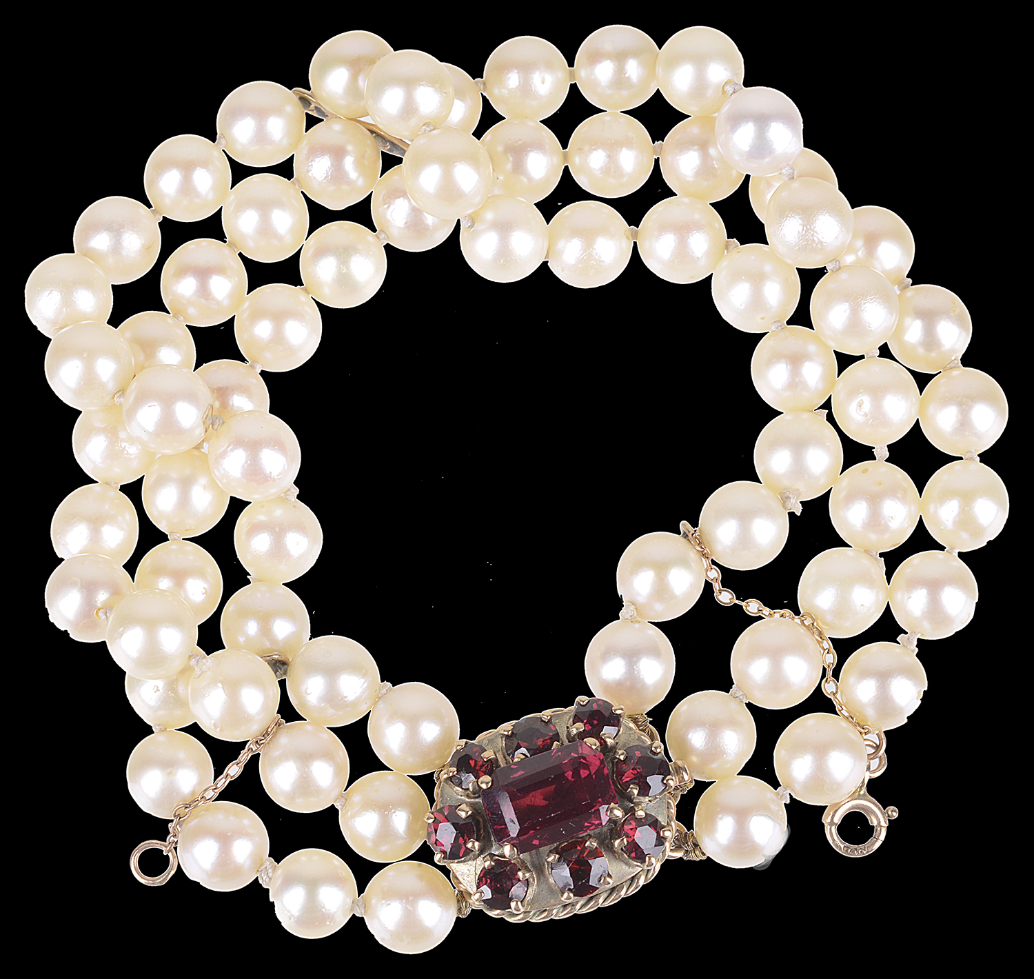 A three row cultured pearl bracelet with garnet set clasp