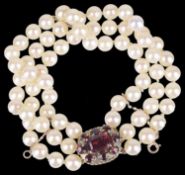 A three row cultured pearl bracelet with garnet set clasp