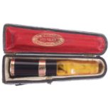 A French 18k gold amber and black Bakelite cheroot holder