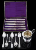 A small collection of silver flatware and a silver jug