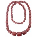 A long red amber graduated large bead necklace