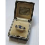 GOLD COLOURED RING SET WITH THREE SAPPHIRES AND TWO CLEAR STONES